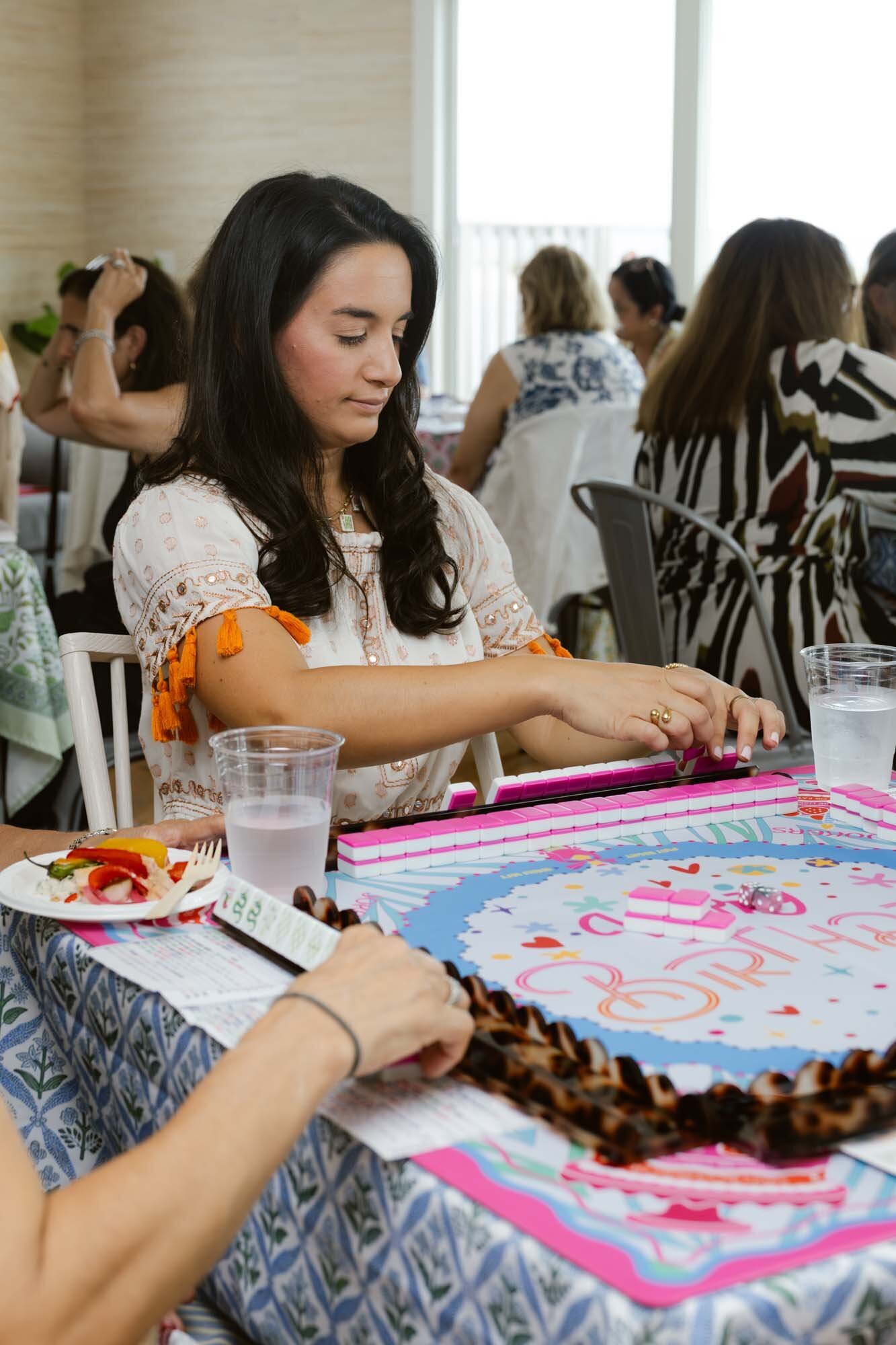 Players gathered around a colorful mahjong table.